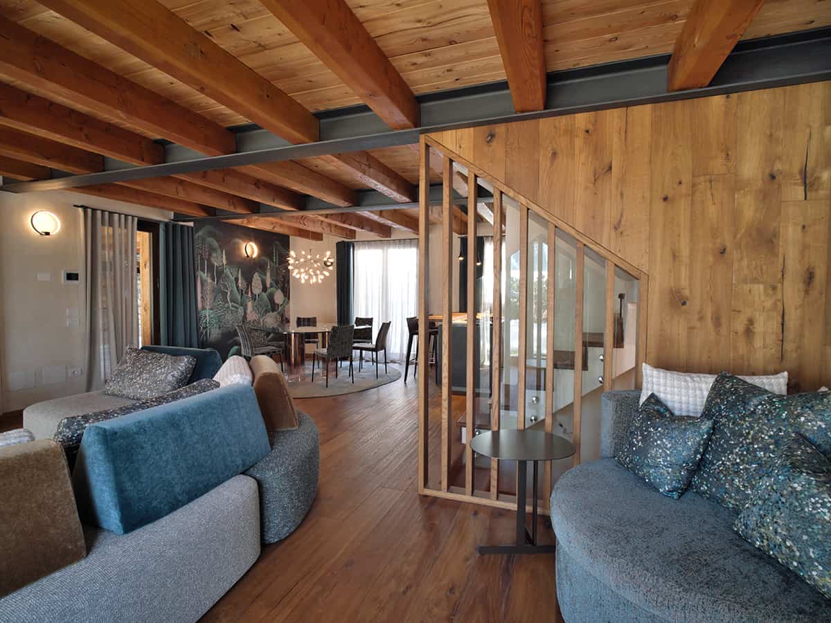 Zona living in legno con divano rivestito e tappeto su misura Tappezziere Dell’Orto